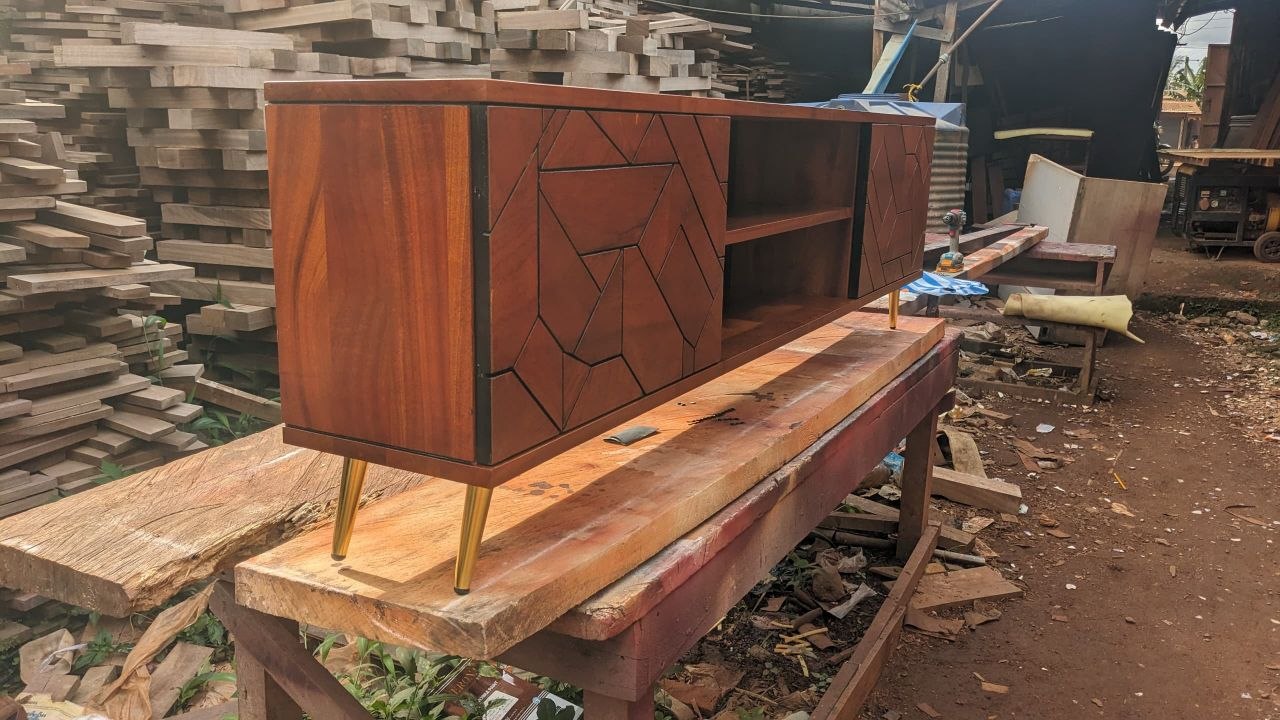 Meuble TV en marqueterie dans l'atelier KDR, réserves de bois en arrière-plan